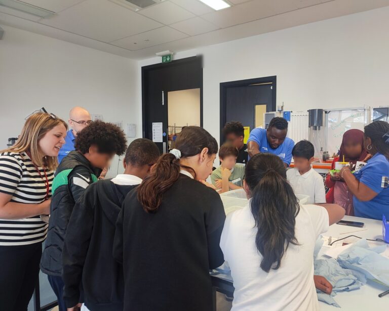 A group of WIRe CDT PhD students work with children in a lab setting