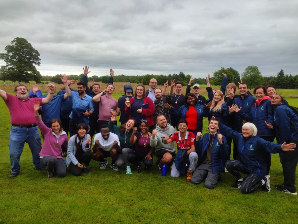 A group of WIRe CDT PhD students and staff looking happy on a field