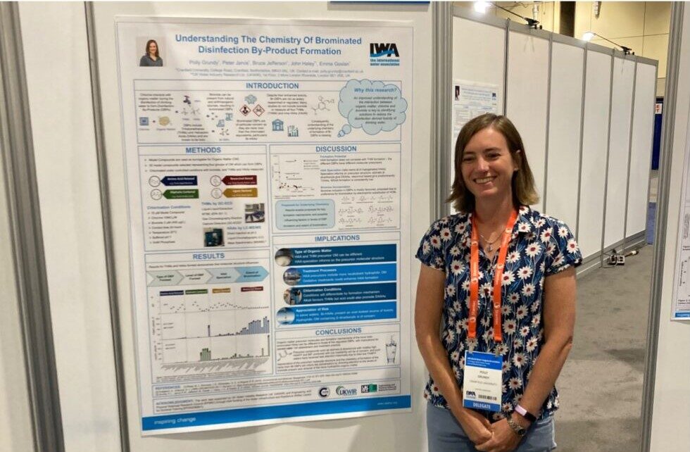 Polly stands next to her scientific conference poster