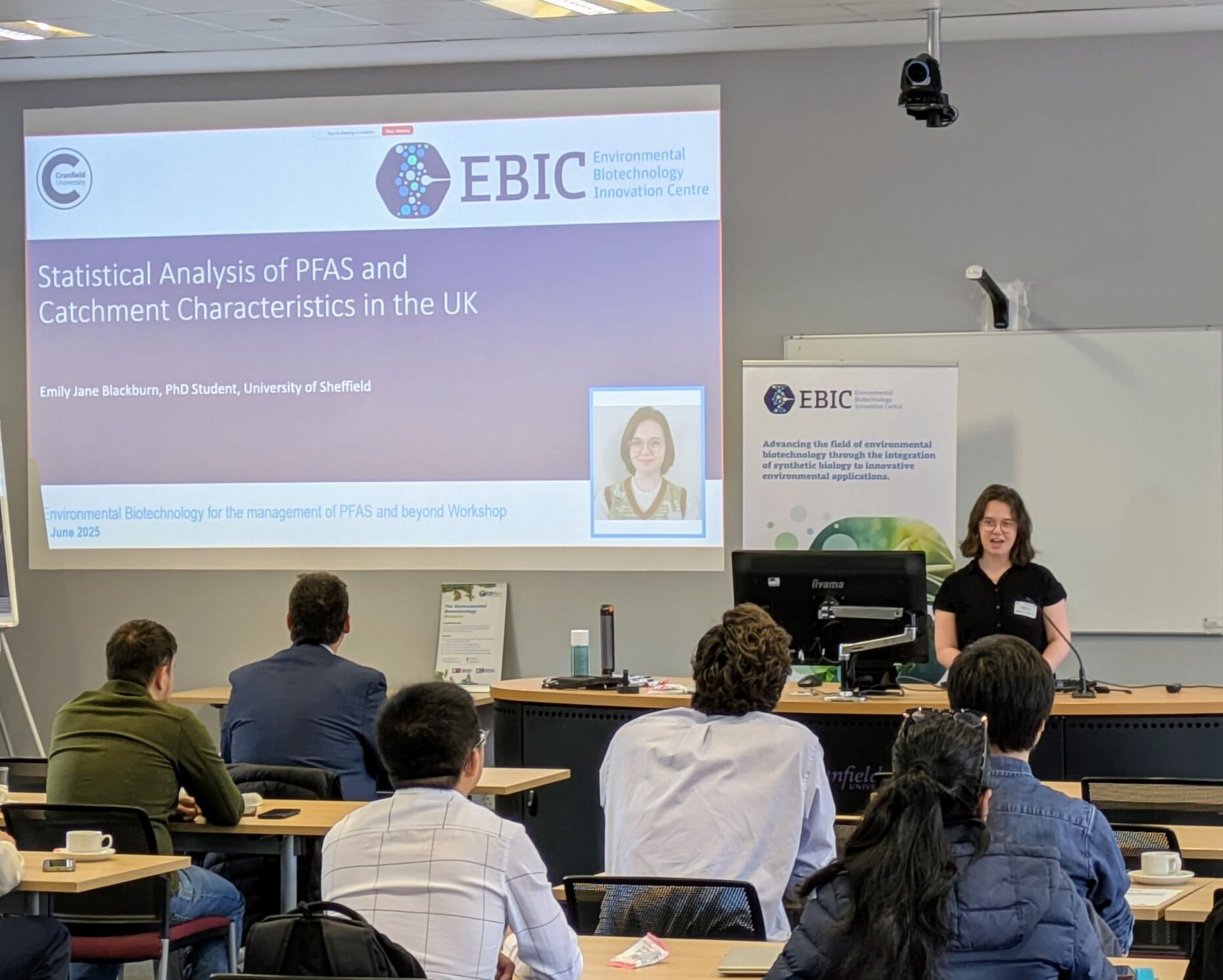 Emily stands at the front of a classroom delivering a presentation