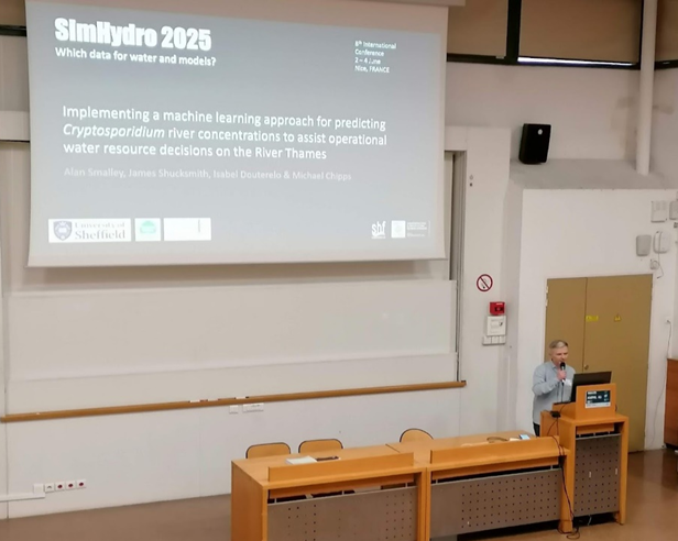 Alan delivering a conference presentation in a lecture theatre
