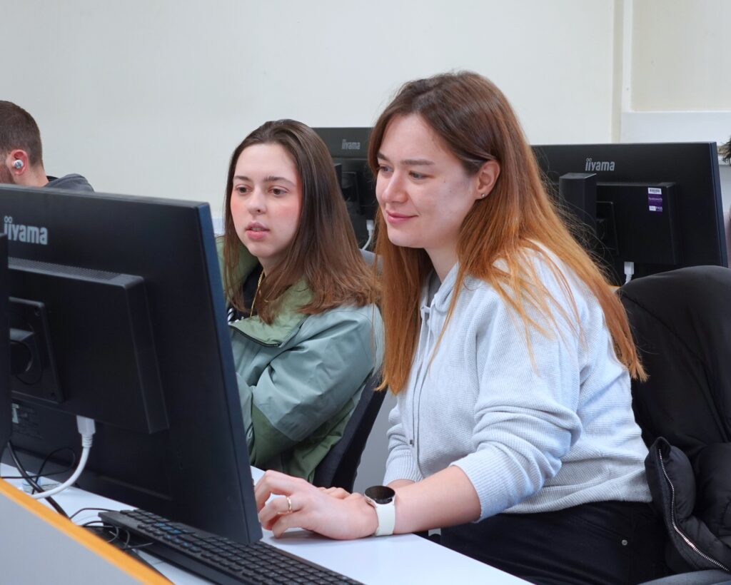 Two women work at computers