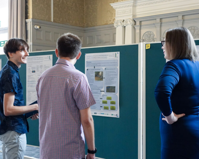 people stood near scientific posters. the people are deep in conversation