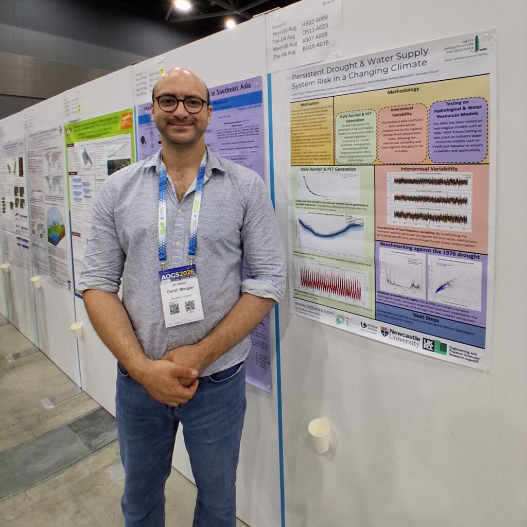 A man stands next to a scientific poster