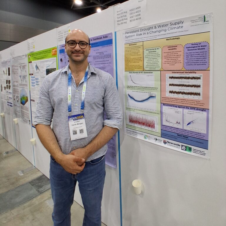 A man stands next to a scientific poster