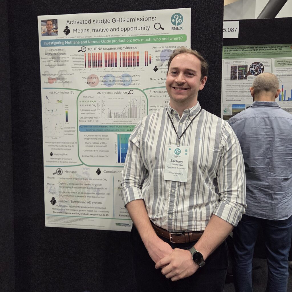 A man stands next to a scientific poster